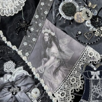 Detail of crazy quilt square with lace, ribbon, buttons, and a Victorian-era image of a woman