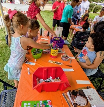 Kids making bookmarks at a table with art supplies